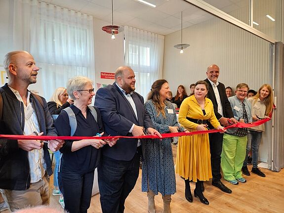 Gemeinsam eröffnen Vertreterinnen und Vertreter aus Verwaltung, wie Staatssekretär Stephan Machulik (Dritter von rechts), und des Pestalozzi-Fröbel-Haus das Nachbarschaftszentrum Bornhagenweg. (Bild: Katja Adelhof)   