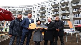 Vertreterinnen und Vertreter aus Politik, Kirche und Wohnungsbau posieren bei der Schlüsselübergabe für den FACE Campus mit einem symbolischen Schlüssel.