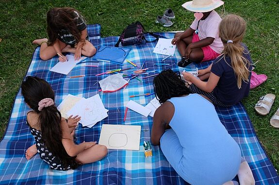 Auf einer Decke konnten sich die Kinder direkt selbst künstlerisch betätigen. (Bild: QM Hellersdorfer Promenade) 