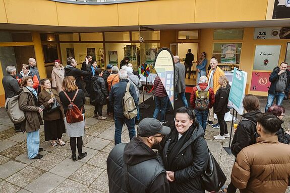 Viele Menschen stehen gemeinsam in einem offenen Raum.