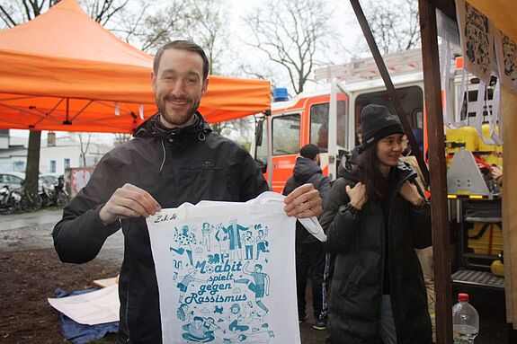 Quartiersmanager Stefan Schulz präsentiert seinen Siebdruck-Beutel mit der Aufschrift „Moabit spielt gegen Rassismus“. (Bild: Gerald Backhaus)