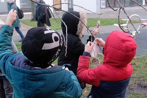 Kinder aus dem Quartier hängen Vogelkuchen in den Bäumen auf. (Foto: Kiezredakteur)