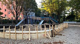 Der Graben für die Sitz- und Spielmauer um ein Kletter- und Rutschelement ist ausgehoben.
