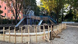 Der Graben für die Sitz- und Spielmauer um ein Kletter- und Rutschelement ist ausgehoben.
