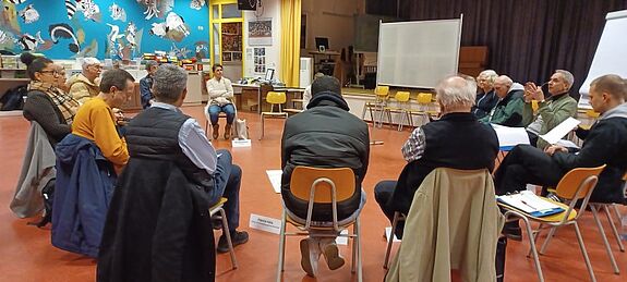 Die Mitglieder des Quartiersrats Nahariyastraße sitzen im Stuhlkreis und besprechen Bauprojekte.