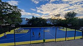 Mädchen und junge Frauen spielen Basketball auf einem bunt markierten Platz an der Albert-Gutzmann-Schule.