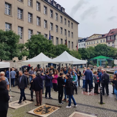 Auf dem Vorplatz des Rathaus Neuköllns trotzen die Feiernden dem Nieselregen. (Bild: Birgit Leiß)