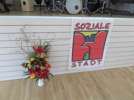 Ein Auftseller mit dem Logo des Programms Soziale Stadt vor der Bühne. Foto: SenSW
