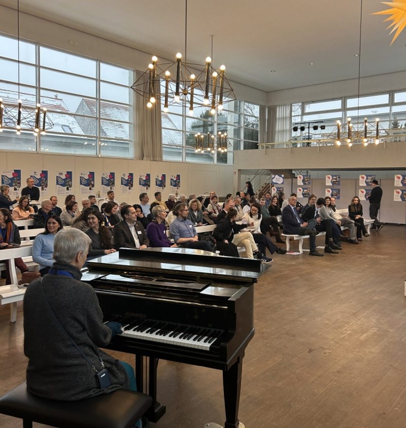 Besucherinnen und Besucher hören Rednerinnen und Rednern sowie einer Pianistin beim Neujahrsempfang im QM-Gebiet Rixdorf zu.