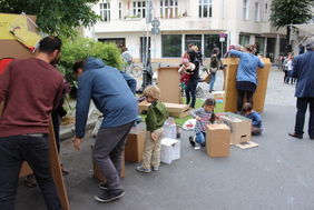 Kinder und Erwachsene bemalen Kisten auf der Straße 
